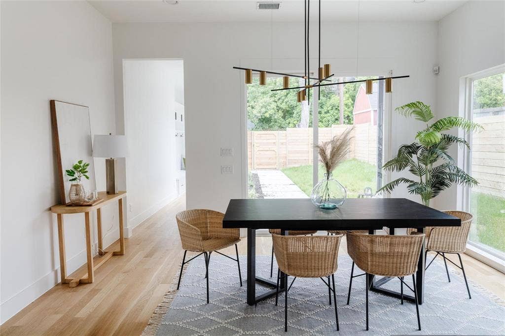 939 N Buckner Boulevard, Dallas, TX 75218 Hardwood flooring, white painted walls, large glass windows, and a modern linear chandelier