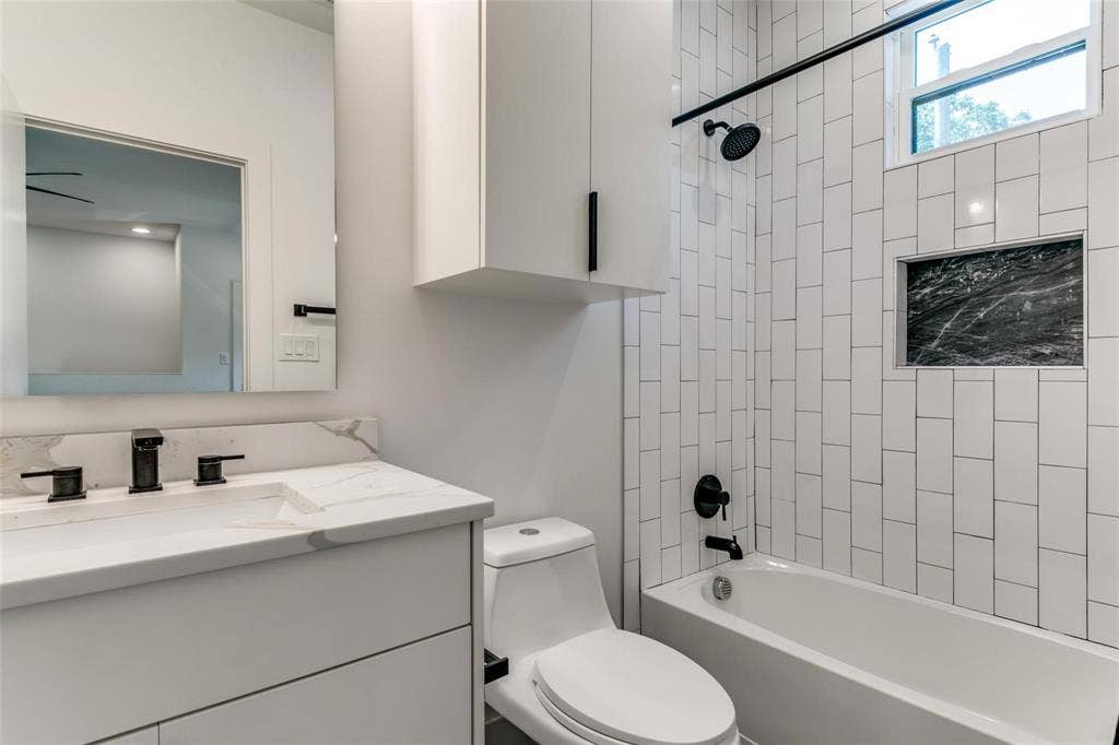 939 N Buckner Boulevard, Dallas, TX 75218 Guest Quarters Bath Modern vanity with integrated sink, black fixtures, and quartz-finish countertop