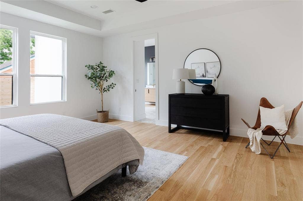 939 N Buckner Boulevard, Dallas, TX 75218 Recessed ceiling lighting, light wood-finish flooring, two large windows, tray ceiling, and a doorway to an adjoining space