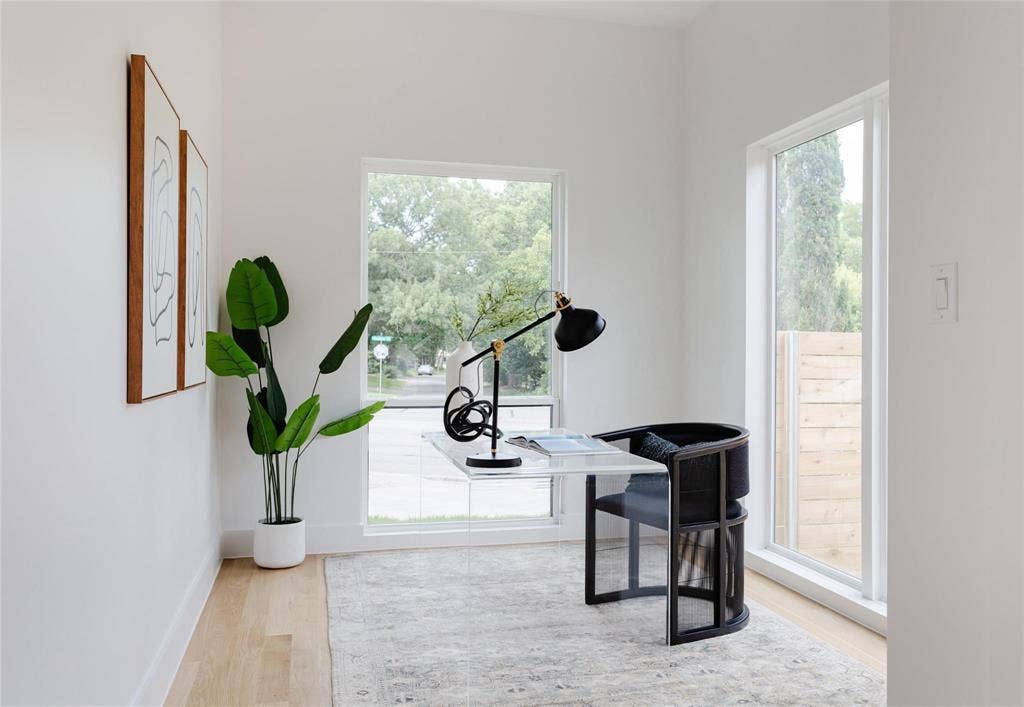 939 N Buckner Boulevard, Dallas, TX 75218 Light-filled interior space featuring wood-finish flooring, white walls, and multiple large windows