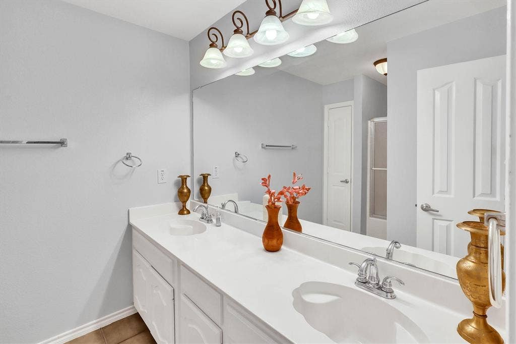 1506 Park Grove Drive, Irving, TX 75060 Dual vanity with integrated sinks, chrome faucets, and a full-width mirror