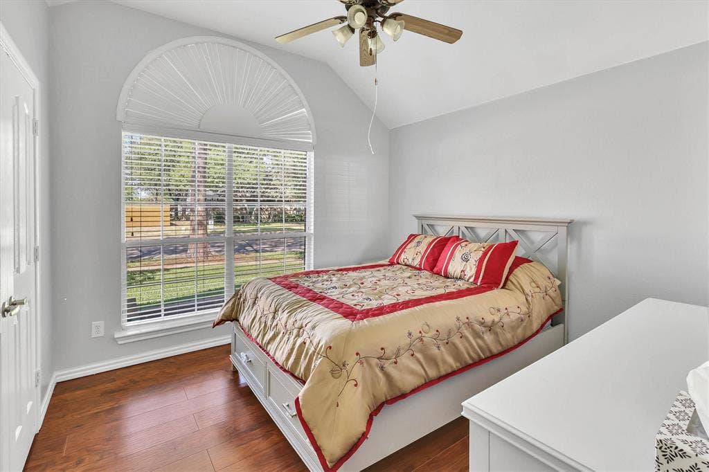 1506 Park Grove Drive, Irving, TX 75060 Vaulted ceiling, arched window with blinds, wood-finish flooring, and a ceiling fan