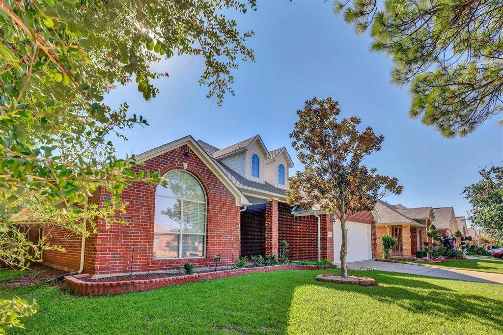 1506 Park Grove Drive, Irving, TX 75060 Red brick exterior with white siding accents and a dormer window