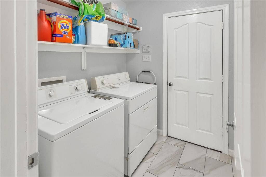 1506 Park Grove Drive, Irving, TX 75060 Utility area featuring white appliances, a paneled door, and two white floating shelves