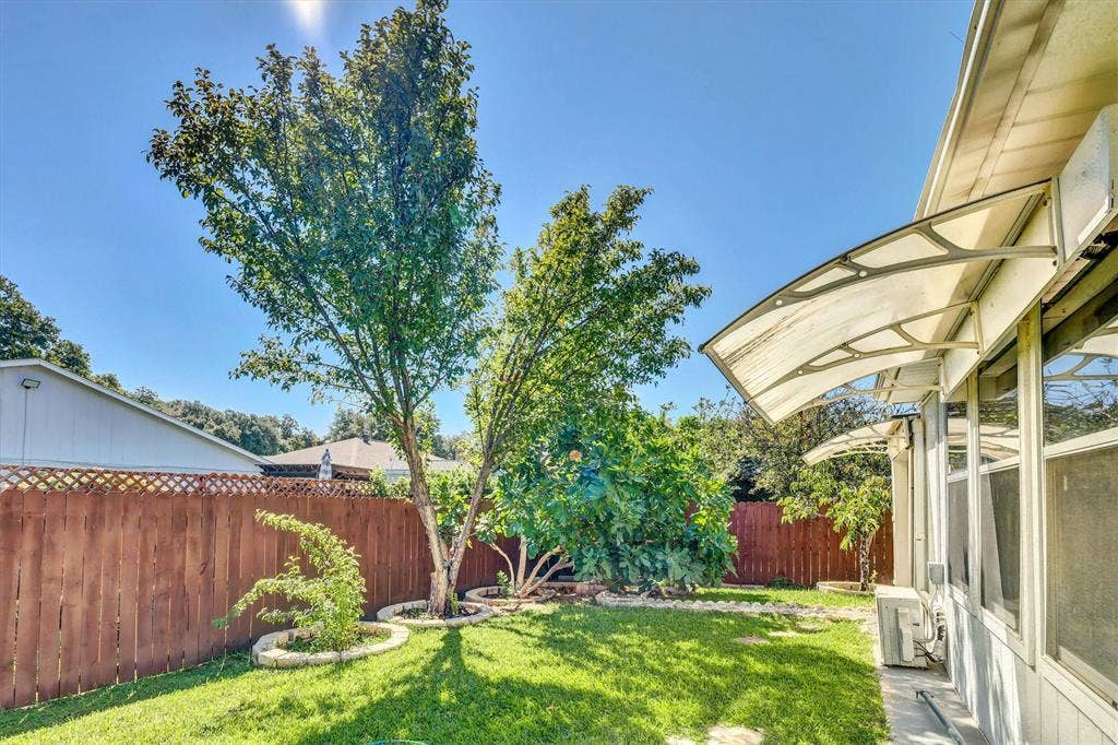 1506 Park Grove Drive, Irving, TX 75060 Fenced backyard featuring a manicured lawn, established trees, and perimeter landscaping