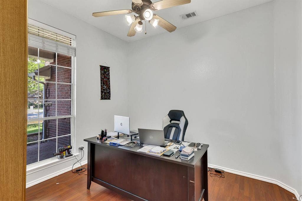 1506 Park Grove Drive, Irving, TX 75060 Wood-finish flooring, ceiling fan with integrated lighting, and a large window with blinds