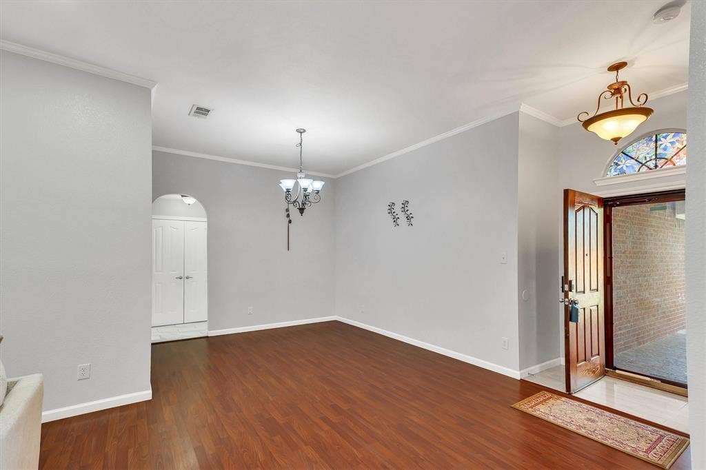 1506 Park Grove Drive, Irving, TX 75060 Wood-finish flooring, crown molding, and a chandelier illuminate the interior