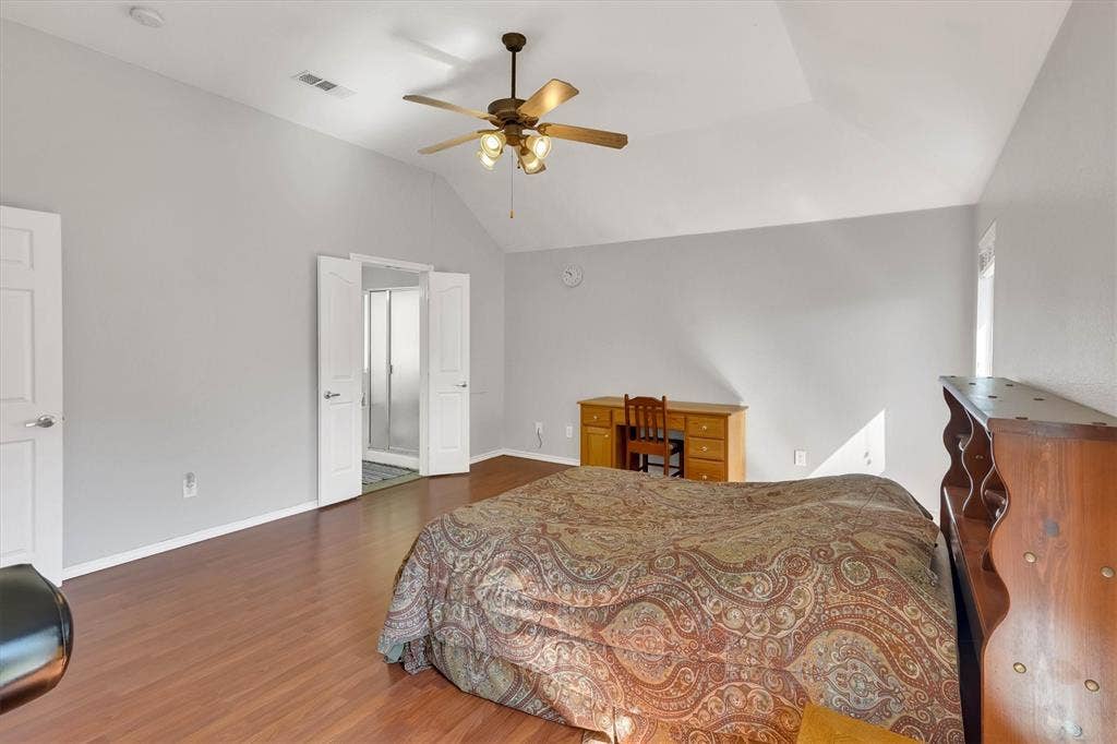 1506 Park Grove Drive, Irving, TX 75060 Vaulted ceiling with ceiling fan, wood-finish flooring, light-toned wall paint, and white paneled doors