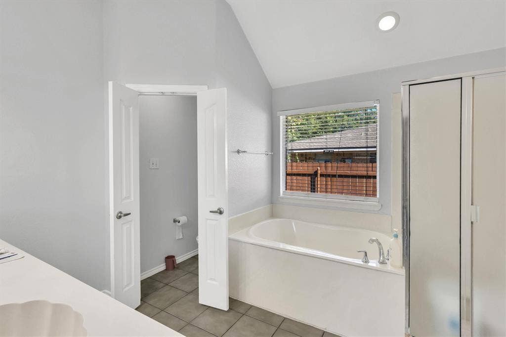1506 Park Grove Drive, Irving, TX 75060 Soaking tub with a window, tile flooring, and a glass-enclosed shower