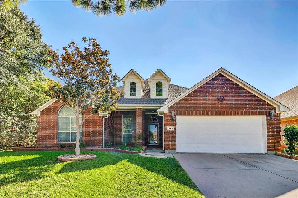 1506 Park Grove Drive, Irving, TX 75060 Brick exterior with a white garage door, gabled roofline, and arched window