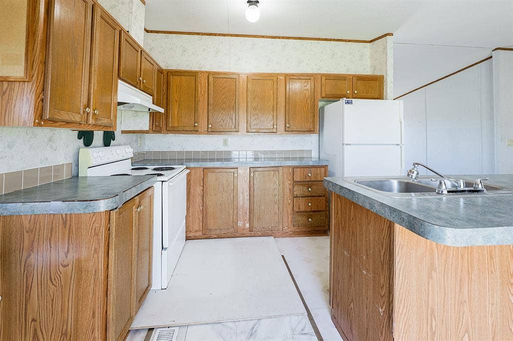 20132 County Road 818, Farmersville, TX 75442 Kitchen featuring wood-finish cabinetry, laminate countertops, and a stainless steel sink