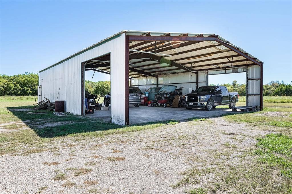 20132 County Road 818, Farmersville, TX 75442 Metal-sided structure with an open bay and overhead door