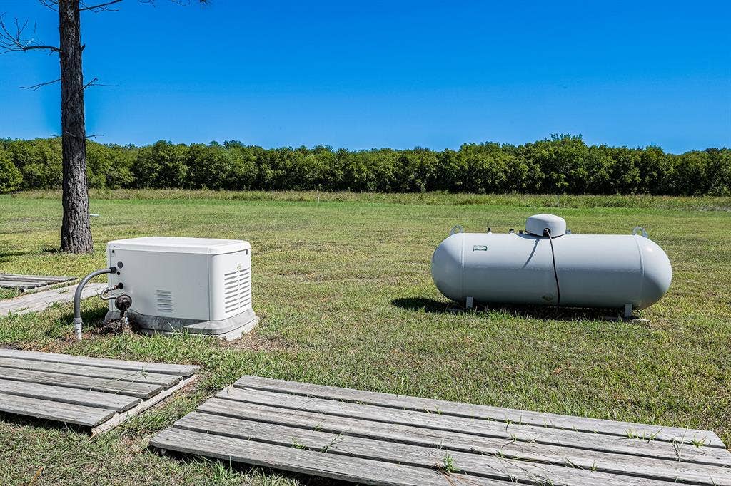 20132 County Road 818, Farmersville, TX 75442 Standby generator and propane tank on a grassy expanse