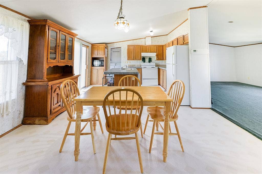 20132 County Road 818, Farmersville, TX 75442 Kitchen area featuring wood-finish cabinetry, white appliances, and a built-in kitchen island