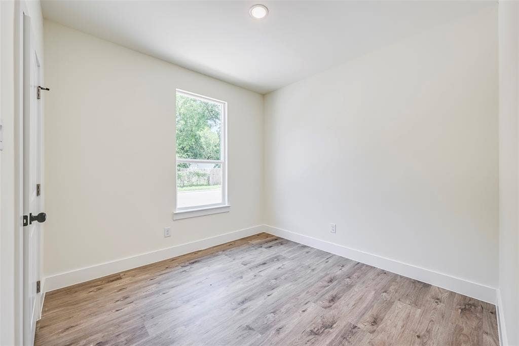 4418 Myrtle, Dallas, TX 75215 Room featuring wood-finish flooring, recessed ceiling light, white baseboards, and a window with a white frame