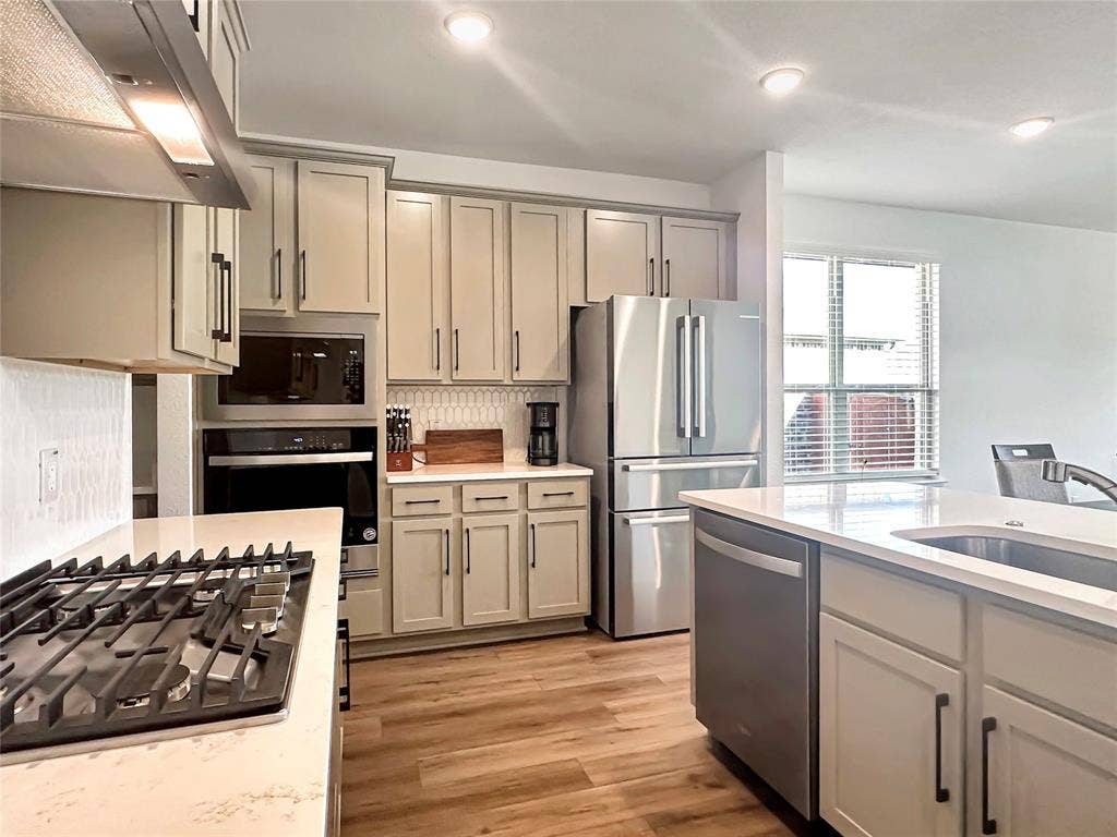 2117 Proteus Drive, Haslet, TX 76052 Kitchen with ventilation hood, light hardwood / wood-style flooring, stainless steel appliances, and gray cabinetry