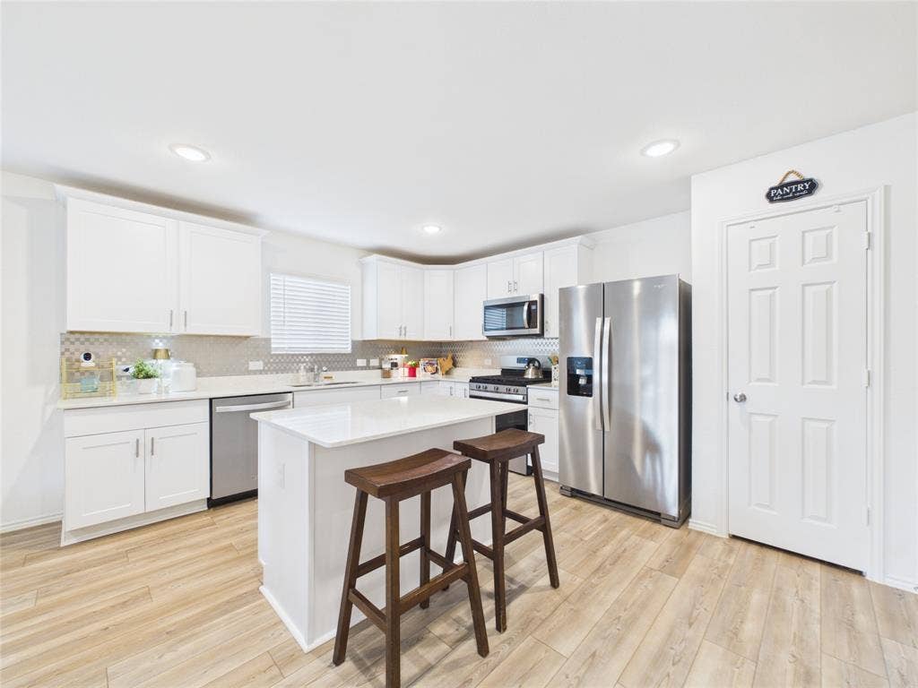 16039 Malaya Street, Haslet, TX 76052 Open kitchen with granite countertops and modern backsplash with stainless steel appliance and island.