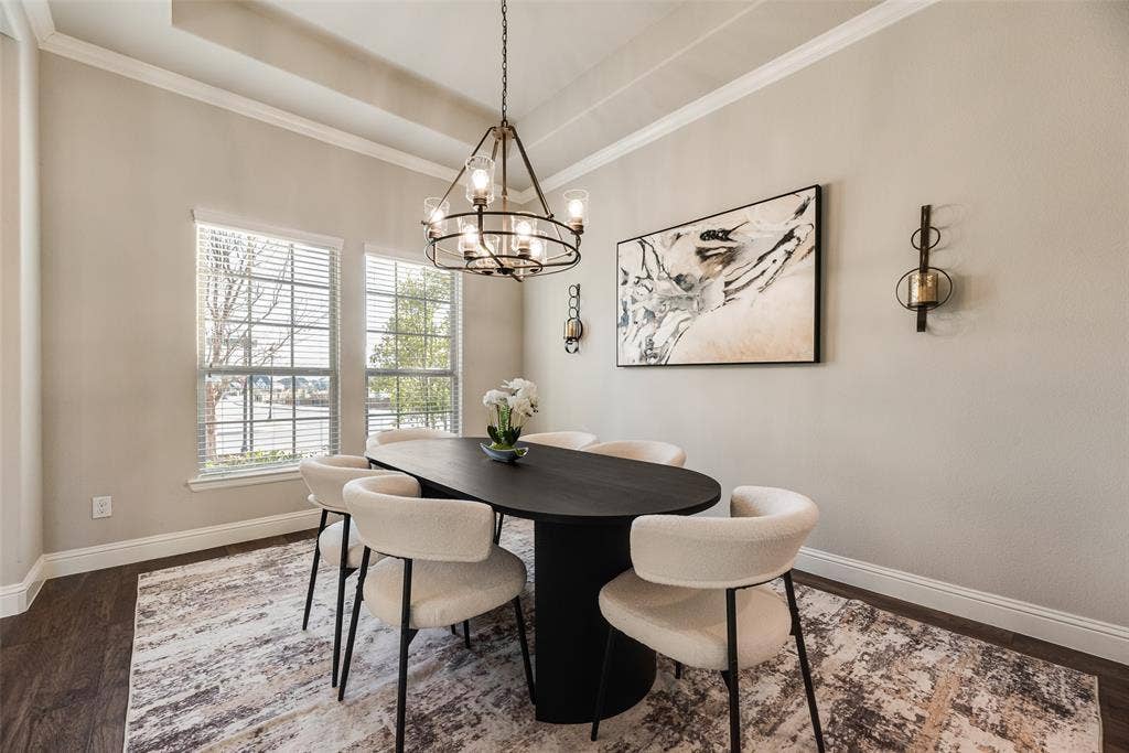 Tray ceiling with crown molding, wood-finish flooring, and two large windows
