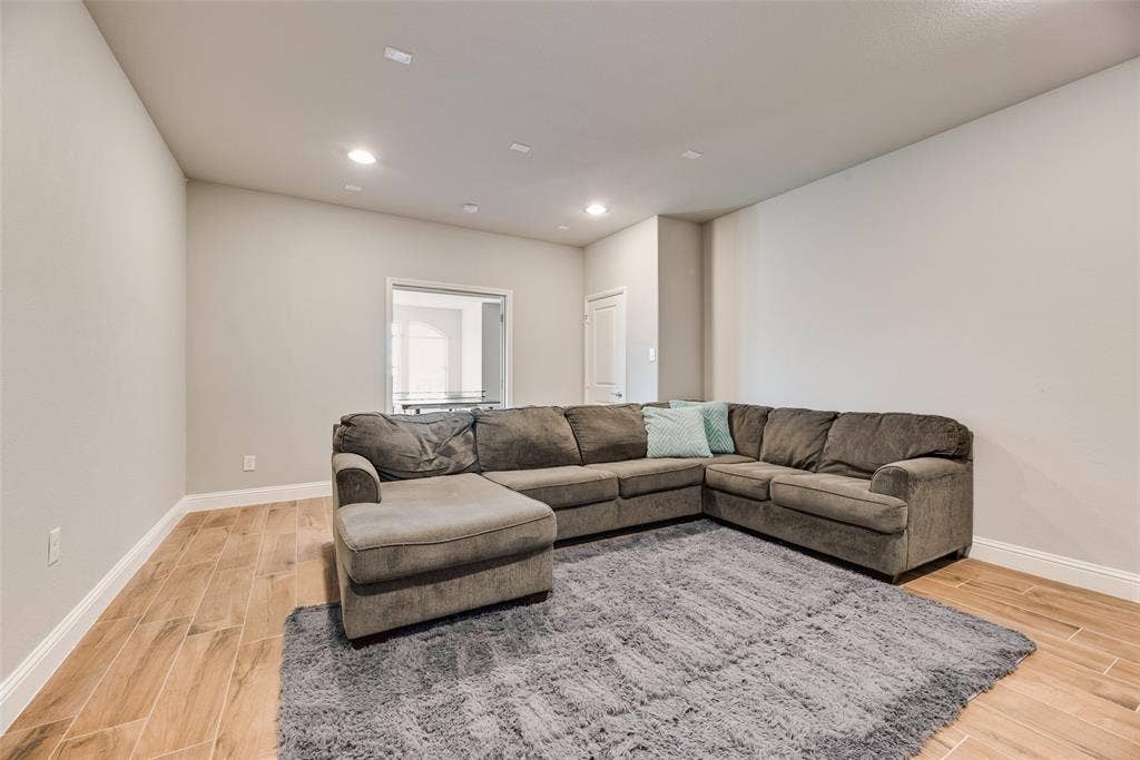 Recessed lighting, wood-finish flooring, and light-toned walls