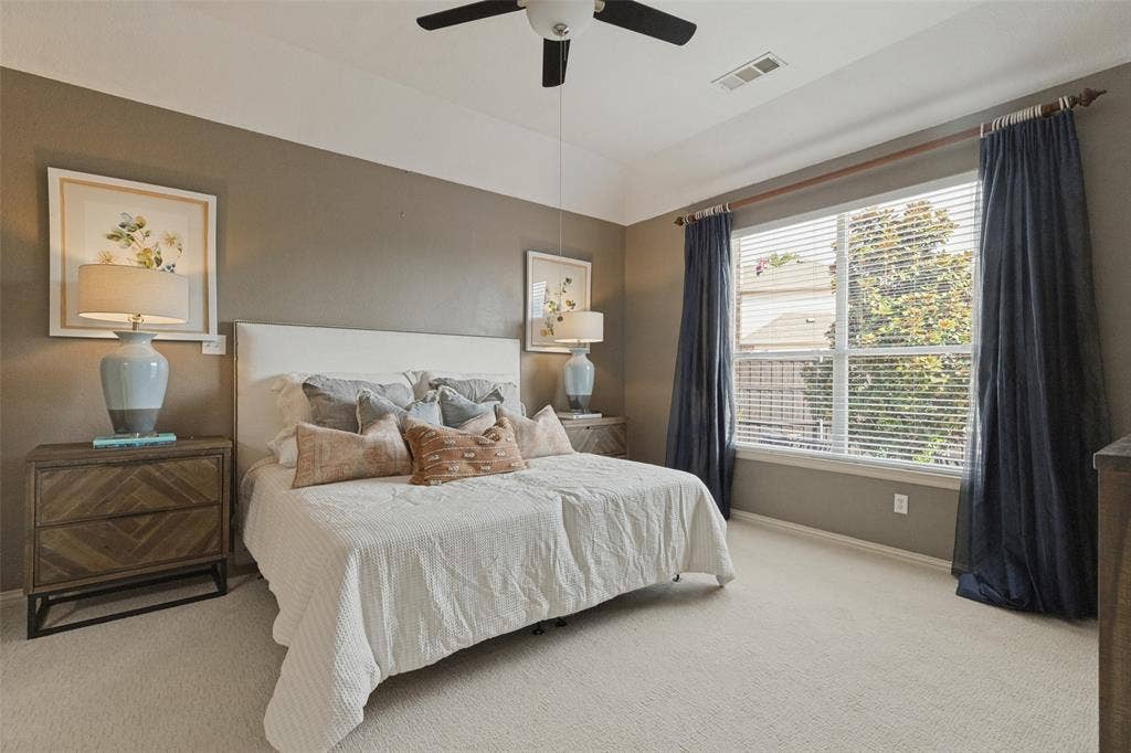 10796 Astoria Drive, Frisco, TX 75035 Spacious primary bedroom featuring brand-new carpet, a tray ceiling, ceiling fan, and large window that fills the room with natural light, creating a comfortable and relaxing retreat.