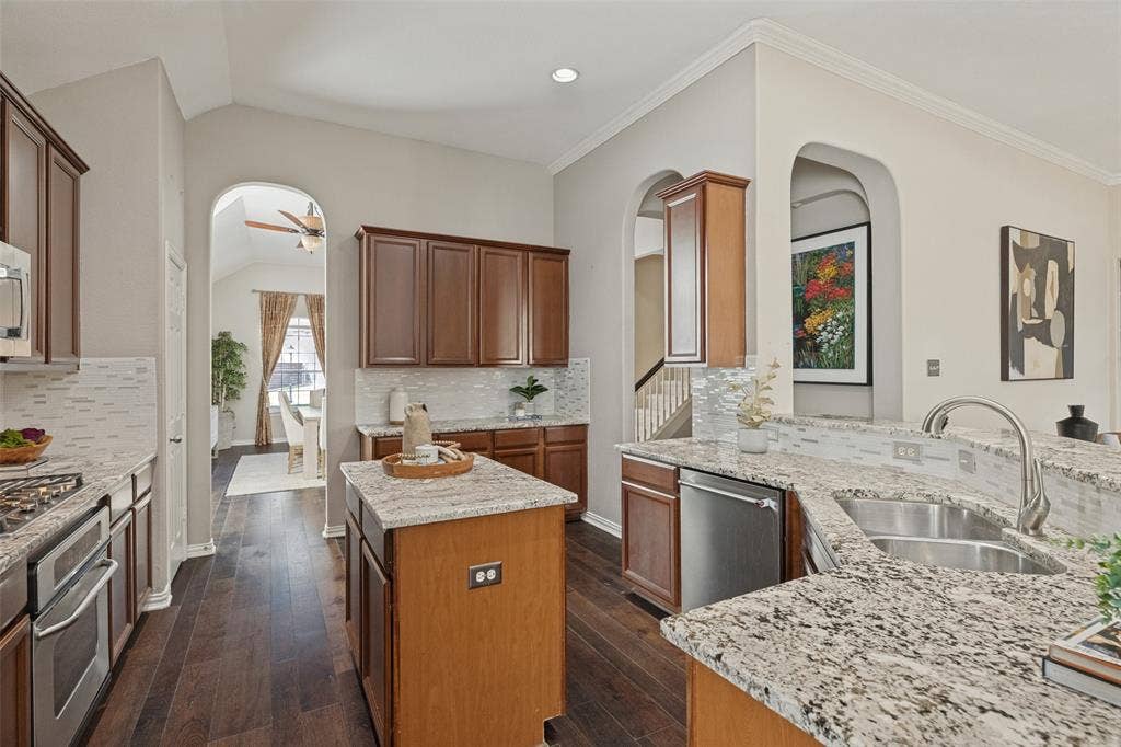 10796 Astoria Drive, Frisco, TX 75035 Spacious kitchen featuring granite countertops, abundant cabinetry, stainless steel appliances, a center island, and an open design that keeps the kitchen connected to the surrounding living and dining spaces.