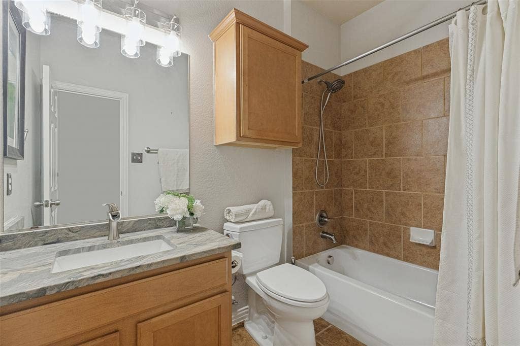 10796 Astoria Drive, Frisco, TX 75035 Secondary full bath features a granite countertop, generous vanity storage, and a tub-shower combination with tile surround.