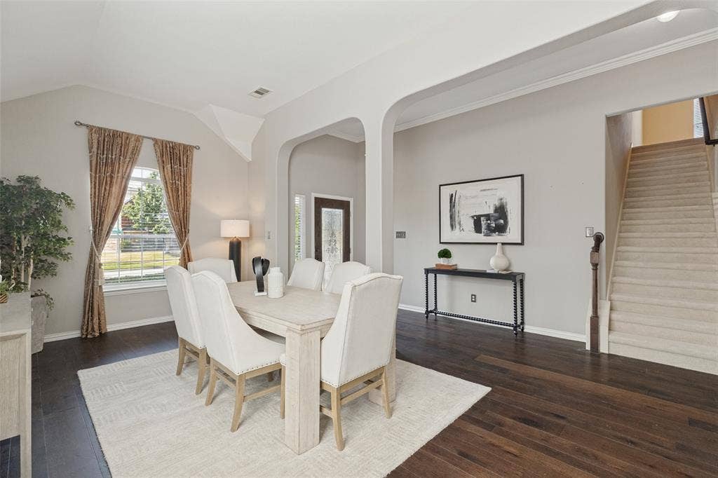 10796 Astoria Drive, Frisco, TX 75035 Spacious formal dining area featuring rich hardwood floors, soaring ceilings, graceful architectural arches, and abundant natural light—perfect for entertaining family and friends.
