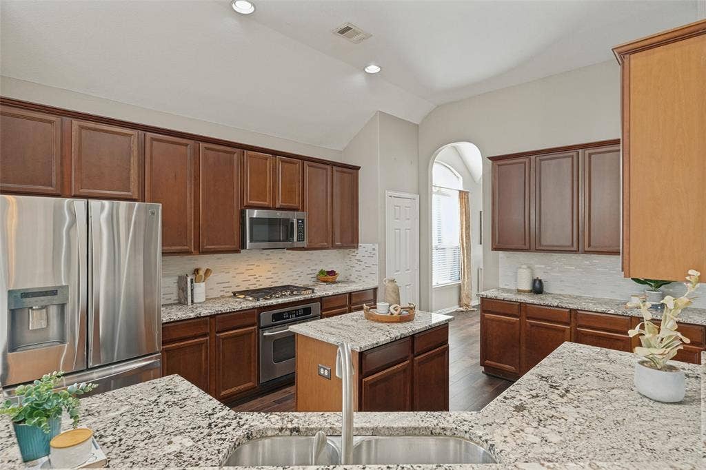 10796 Astoria Drive, Frisco, TX 75035 Spacious kitchen showcasing extensive cabinetry, granite countertops, stainless steel appliances, a center island, gas cooktop, and generous counter space for meal prep and entertaining.