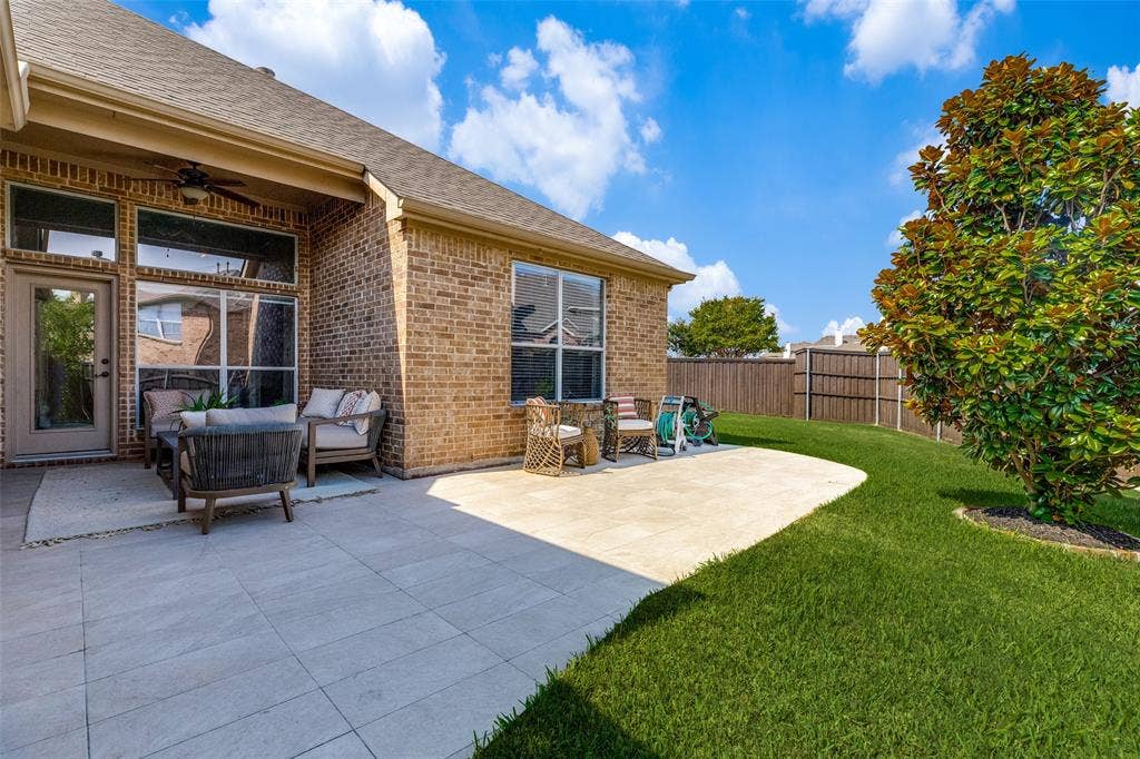 10796 Astoria Drive, Frisco, TX 75035 Spacious backyard features an extended patio with a covered seating area and ceiling fan, plus a beautifully maintained lawn with plenty of room to relax, entertain, and enjoy the outdoors.