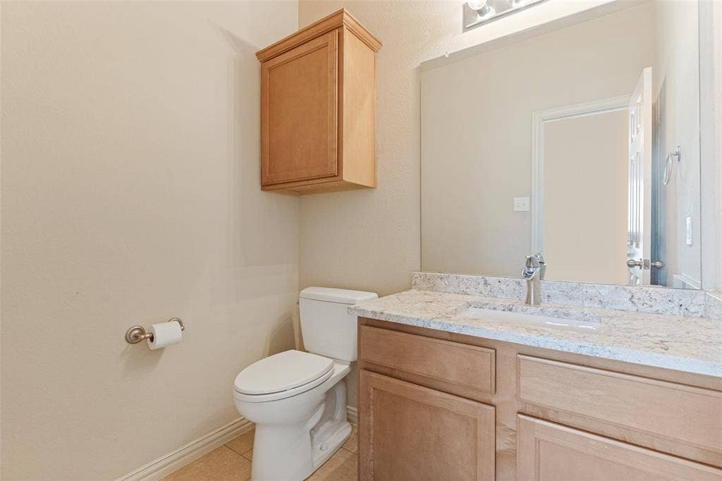 10796 Astoria Drive, Frisco, TX 75035 Convenient upstairs half bath featuring a granite countertop, ample vanity storage, and a clean, neutral design
