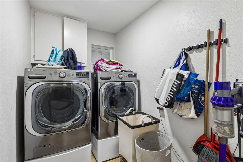 2408 Grandview Drive, Plano, TX 75075 Laundry area featuring a side-by-side washer and dryer, upper cabinetry, and a window