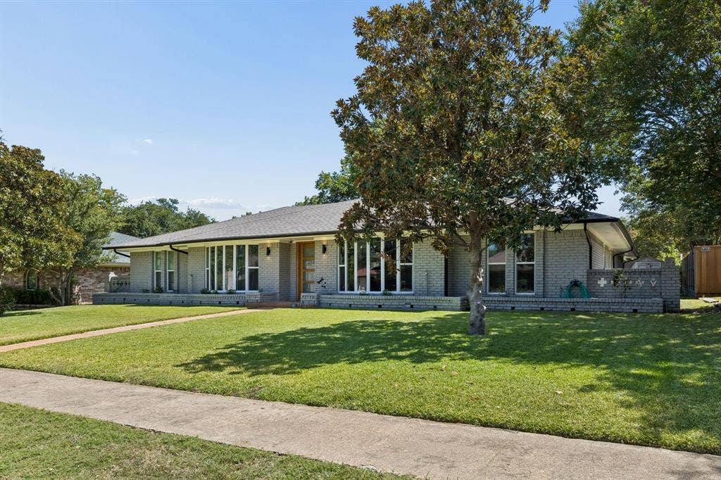 2408 Grandview Drive, Plano, TX 75075 Gray brick exterior with a dark shingle roof, a front walkway, and mature trees