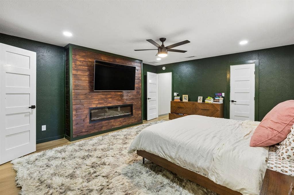 2408 Grandview Drive, Plano, TX 75075 Wood-finish accent wall with integrated linear fireplace, recessed lighting, and a ceiling fan