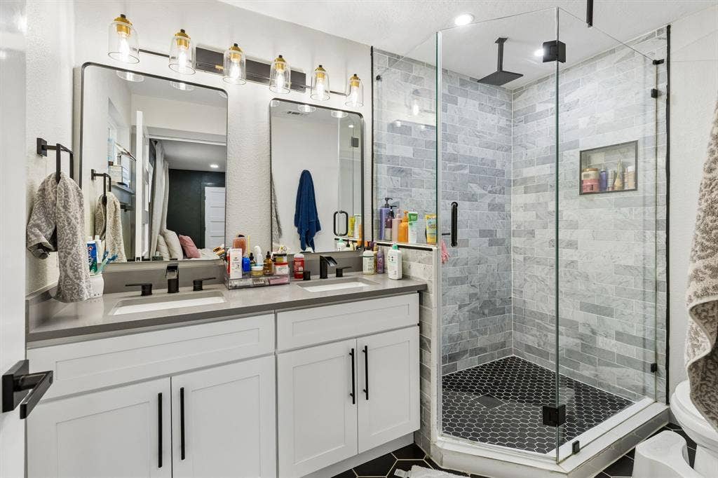 2408 Grandview Drive, Plano, TX 75075 Dual vanity with white cabinetry, matte black hardware, and rectangular undermount sinks