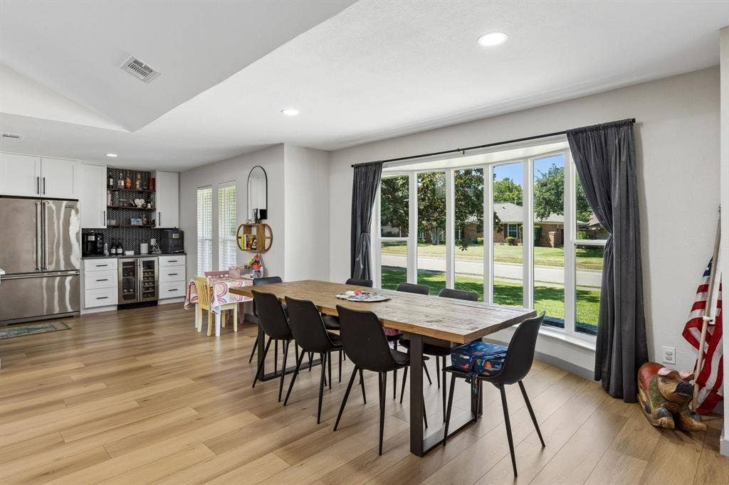 2408 Grandview Drive, Plano, TX 75075 Wood-finish flooring throughout, bay window with multiple panes, recessed ceiling lighting, built-in beverage refrigerator, and white cabinetry with dark hardware