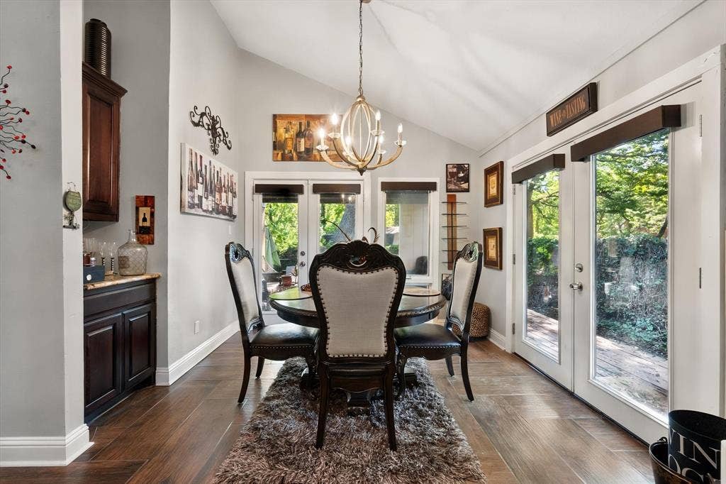 656 The Meadows Parkway, DeSoto, TX 75115 Vaulted ceiling with an ornate chandelier, wood-finish flooring, built-in cabinetry with a stone countertop, and glass-paneled doors