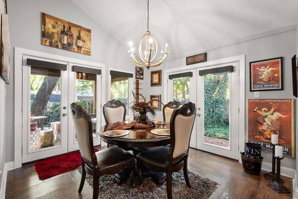 656 The Meadows Parkway, DeSoto, TX 75115 Vaulted ceiling with a chandelier, wood-finish flooring, and multiple glass-paned doors