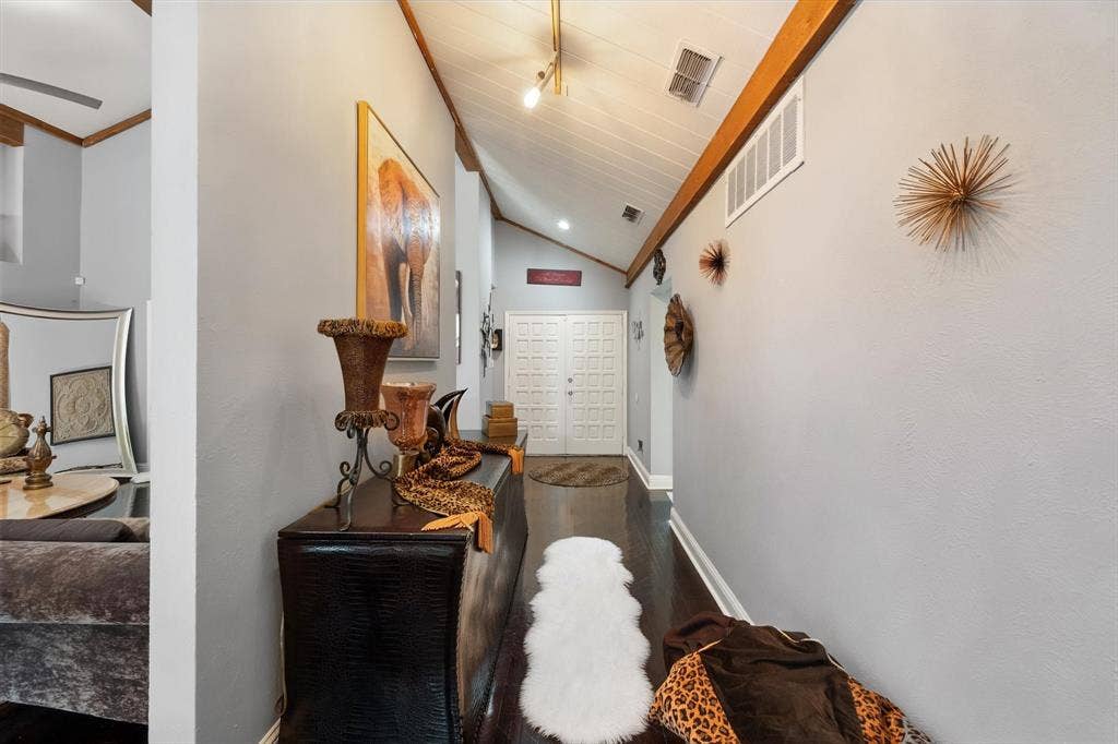 656 The Meadows Parkway, DeSoto, TX 75115 Vaulted ceiling with exposed wood beams, track lighting, wood-finish flooring, and a paneled entry door