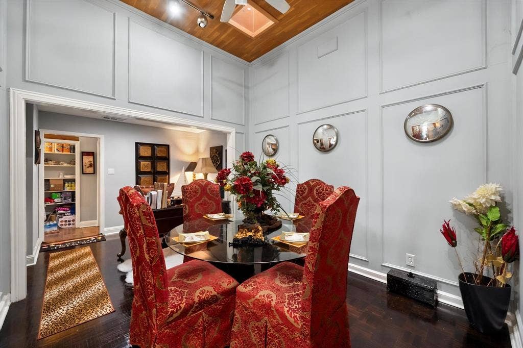 656 The Meadows Parkway, DeSoto, TX 75115 Board and batten wall detailing, dark wood-finish flooring, vaulted ceiling with wood-paneled accent, track lighting, and a wide cased opening