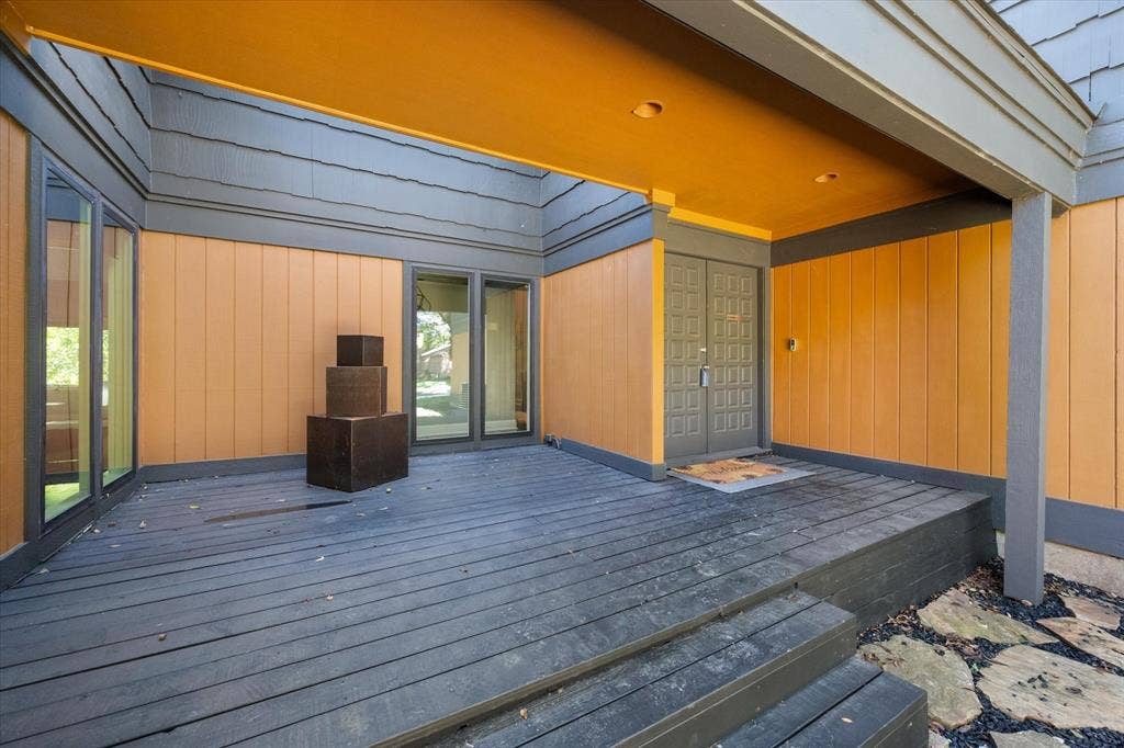 656 The Meadows Parkway, DeSoto, TX 75115 Recessed entry featuring a wood deck, dual entry doors, multiple windows, and exterior wall paneling