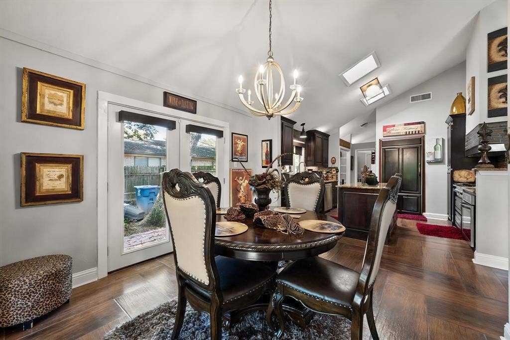 656 The Meadows Parkway, DeSoto, TX 75115 Vaulted ceiling with skylights, wood-finish flooring, French doors, recessed lighting, and a contemporary chandelier
