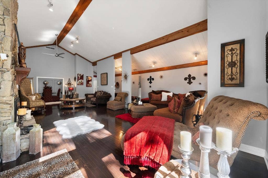 656 The Meadows Parkway, DeSoto, TX 75115 Vaulted ceilings with exposed wood beams, stone-clad fireplace with wood mantel, dark wood-finish flooring, and recessed lighting