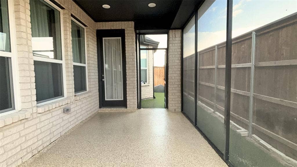 1613 Sandhill Lane, Celina, TX 75009 Covered patio featuring a light-colored brick exterior, a door with a full-length glass insert, and a durable textured floor coating