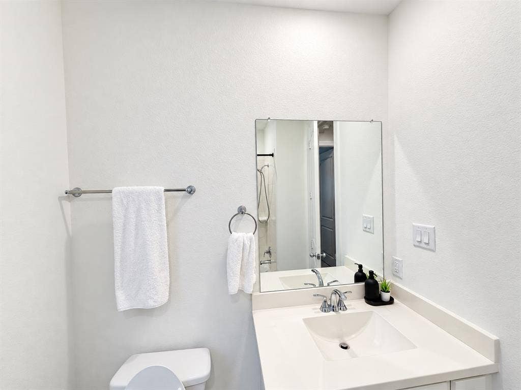 1613 Sandhill Lane, Celina, TX 75009 Vanity with an integrated sink and chrome faucet, rectangular wall-mounted mirror, and a toilet