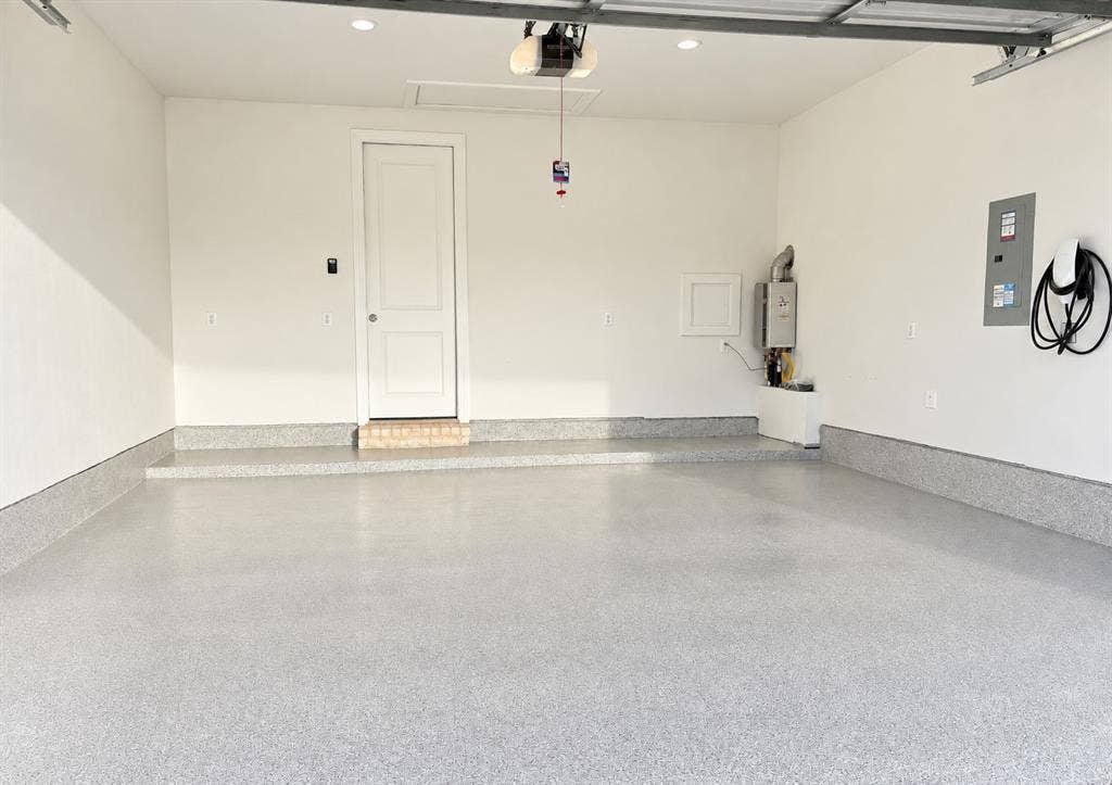 1613 Sandhill Lane, Celina, TX 75009 Spacious garage featuring a durable epoxy floor, electric vehicle charging station, and tankless water heater