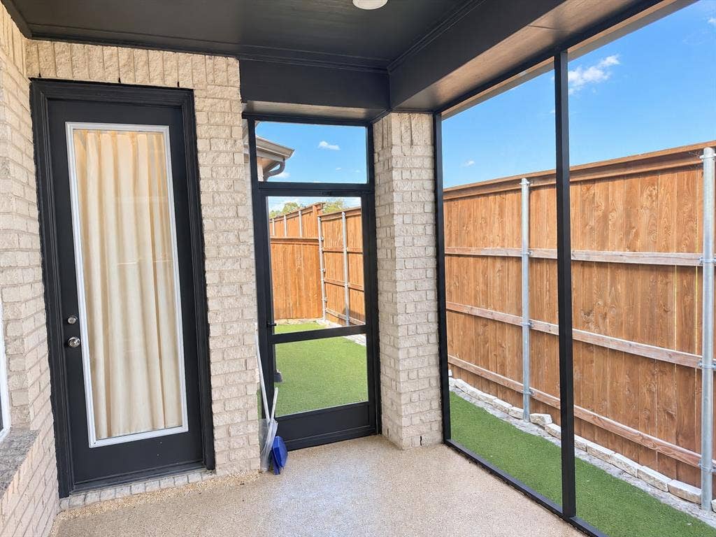 1613 Sandhill Lane, Celina, TX 75009 Screened-in patio featuring light brick exterior, dark trim, and a wood privacy fence