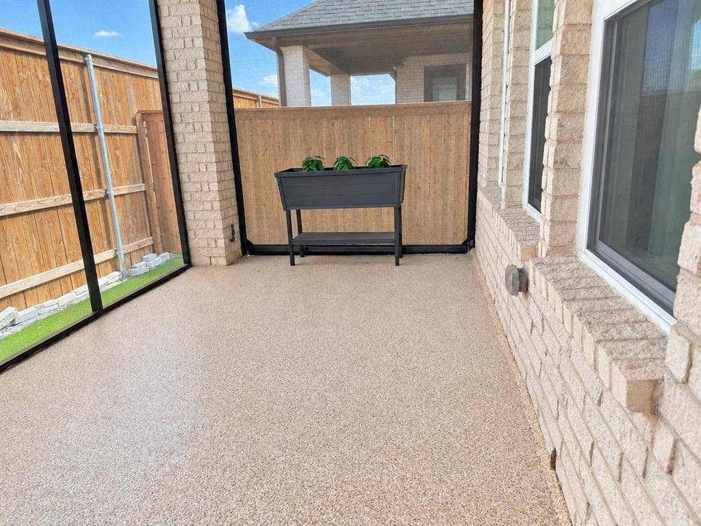 1613 Sandhill Lane, Celina, TX 75009 Screened outdoor living area with a textured flooring surface, brick exterior wall, and multiple windows