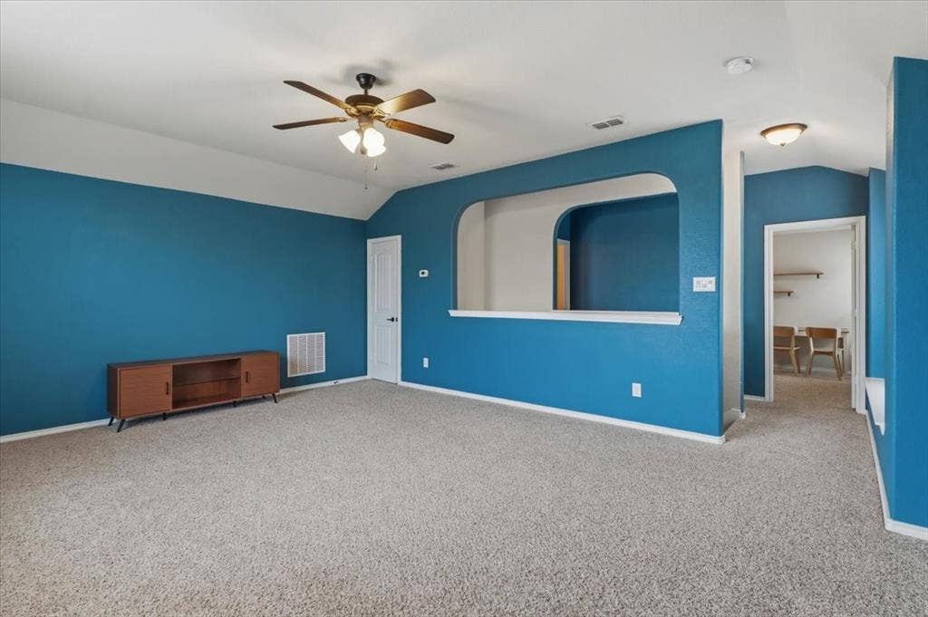 1713 Falling Star Drive, Fort Worth, TX 76052 Vaulted ceiling with a ceiling fan, plush carpet flooring, and an arched wall opening
