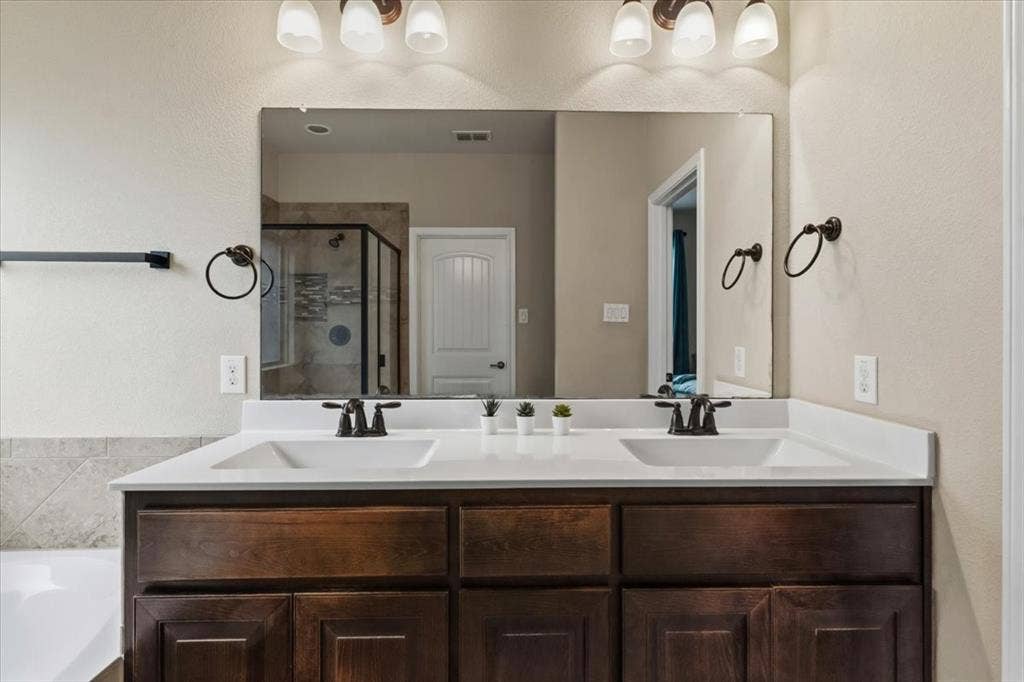 1713 Falling Star Drive, Fort Worth, TX 76052 Double vanity with dark wood-finish cabinetry, white countertops, and integrated rectangular sinks