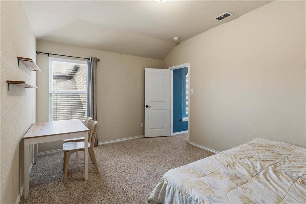 1713 Falling Star Drive, Fort Worth, TX 76052 Vaulted ceiling, neutral tone walls, carpeted flooring, built-in shelving, and a bright window with blinds